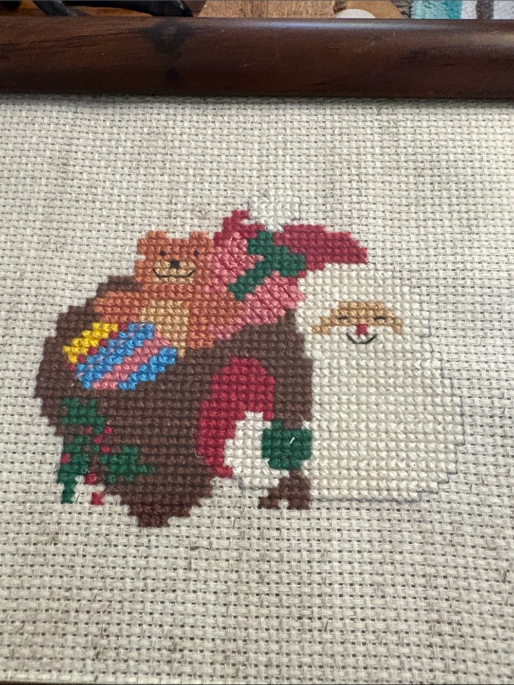 Handmade cross stitch Santa holding a bag of toys framed